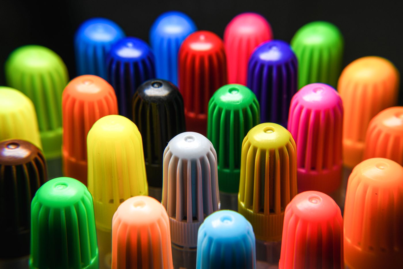Bright marker caps arranged as a color field